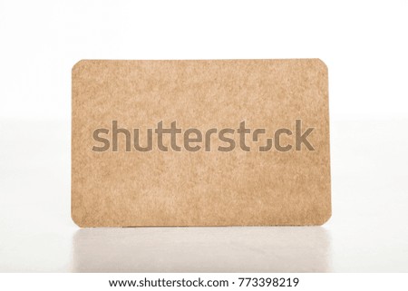 A mockup for a kraft business card, side view on light textures, with a place for text