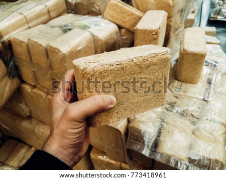 Alternative fuel, eco fuel, bio fuel. Wood sawdust briquettes for stoves. Lean-burn with good heat output. Briquettes from sawdust on a green background. Royalty-Free Stock Photo #773418961