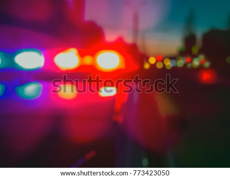 Lights of police car in night time. Night patrolling the city, lights flashing. Abstract blurry image.