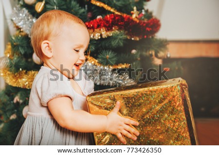 Adorable 1 year old baby girl enjoying Christmas at home