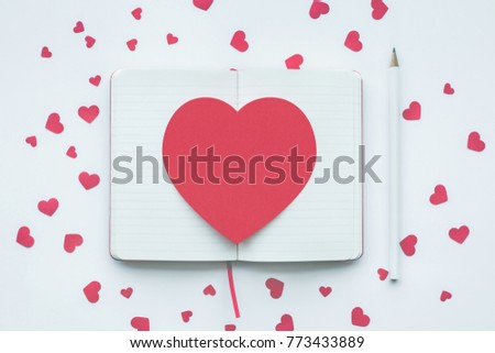 Red heart shape on white notepad background.love,
valentine,wedding concepts ideas