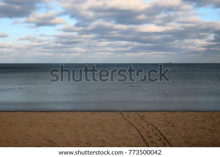 Baltic sea coast, beach and Baltic sea in winter time, cloudy sky, long exposure