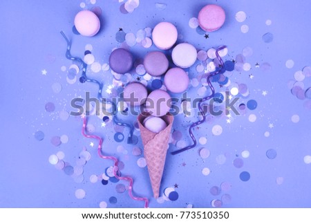 Group of Ultra Violet macarons in ice cream corn on trendy blue festive background. Royalty-Free Stock Photo #773510350