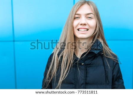 Portrait of a cheerful and smiling girl on blue background, with isolated place for text. high quality photos