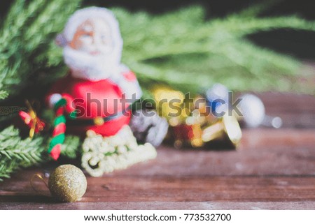 blur of Santa Claus doll  on the brown wood floor with letter Merry Christmas and bells on the brown wood  floor for background.