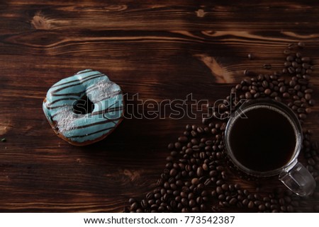 Sweet donuts and tea on a dessert on a wooden texture background