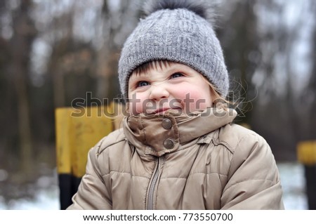 Happy child playing outdoors. Kid having fun in winter park