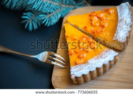 Two slices pumpkin pie with sea buckthorn berries
