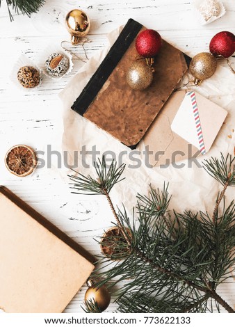 Christmas background. White table with decorations and tree. Post cards. Old book