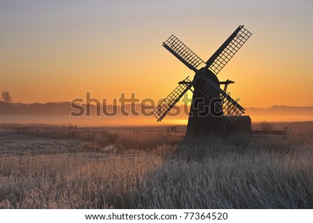 Herringfleet smock mill in the mist on a winter morning. Royalty-Free Stock Photo #77364520