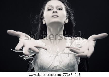 Pretty girl in white posing over dark background