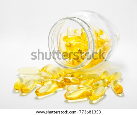 Fish oil capsules in a glass jar isolated on white background.