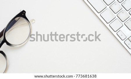 Office desk table with keyboard and glasses  close up Top view on white background