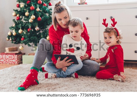 Happy family with tablet sitting on the floor, Christmas concept