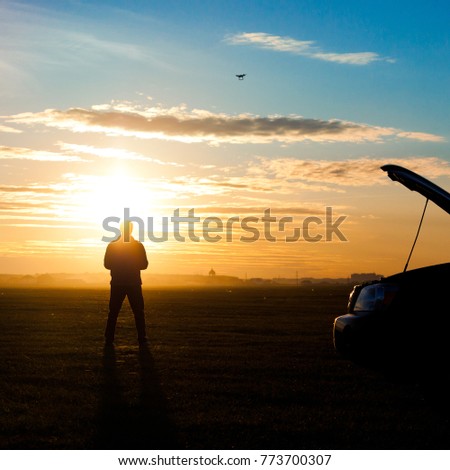 Picture of man silhouette with rc plane standing on sunset