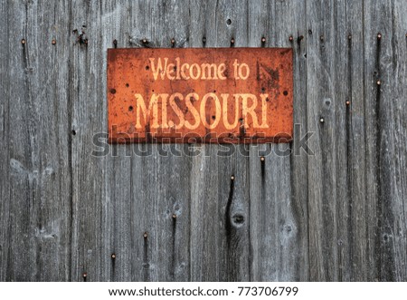 Rusty metal sign on wooden wall with the phrase: Welcome to Missouri.
