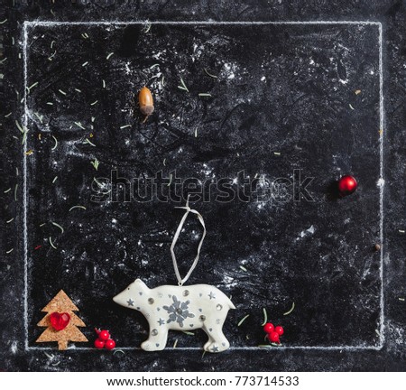 Winter plot. flat toys of a polar bear and a Christmas tree in a white frame on a dark background
