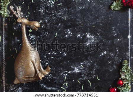 Winter plot. a toy of a merry bronze moose in a white frame on a dark background
