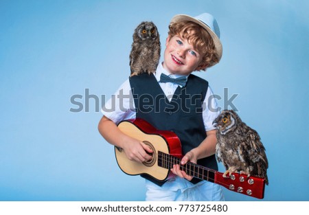 red-haired boy with freckles and his feathered friend owl, kid and owl, boy with red hair and bird of prey on the shoulder are best friends, happy freckles face
