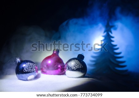 Christmas toys at decorative fir-tree in snow. Making a Christmas tree on table. Empty space. Useful as greeting card