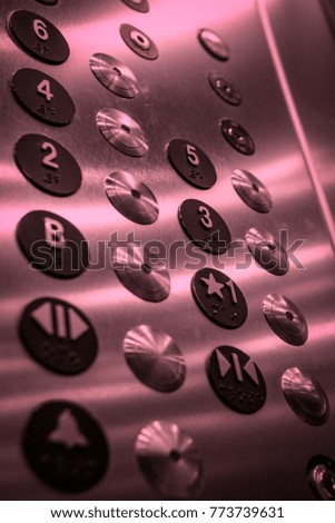 Close up of buttons on an elevator with a pink hue Royalty-Free Stock Photo #773739631