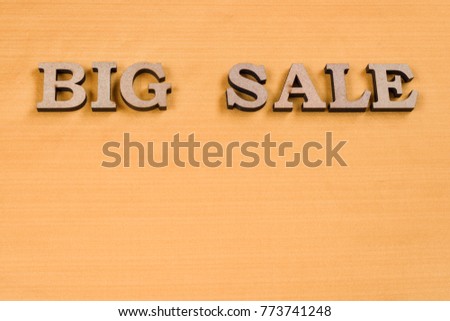 Word BIG SALE abstract wooden letters, background yellow silk texture