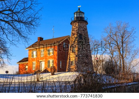Lighthouse on a clear winter day with snow on then ground and a blue sky Royalty-Free Stock Photo #773741830