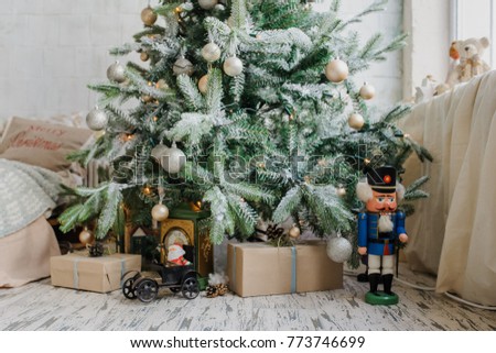 Close up christmas tree with presents and toys, balls, and artificial snow
