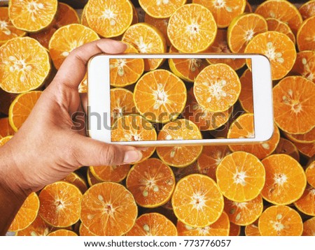 Taking a photo of orange fruit background with smart phone
