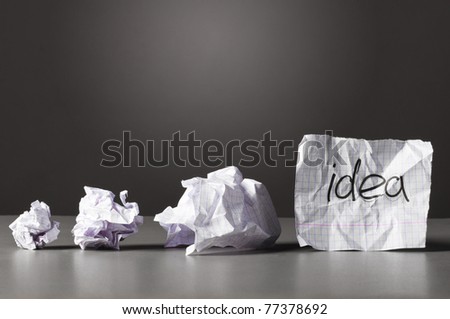 sheet of paper with word idea and crumpled wads on table. Royalty-Free Stock Photo #77378692
