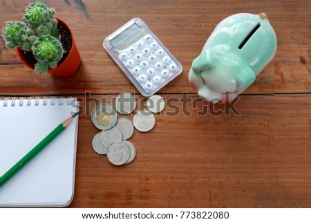 Saving concept with piggy ,coin,calculator on wood table,top view for copy space
