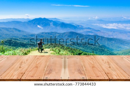 Look out from the table. blur images of tourists are photographed on high mountain scenery as background.