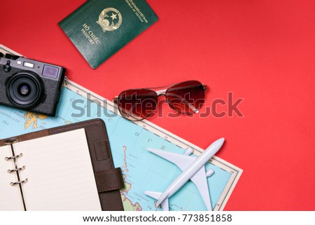 Preparation for travel concept - Toy plane, camera, cup of tea, clothes on wooden background.