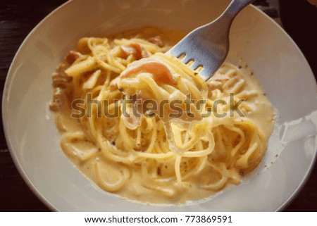 Close-up of spaghetti carbonara on fork.
