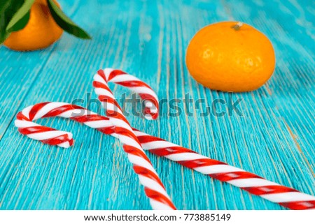 candy canes heart and tangerines on turquoise wooden planks, xmas background