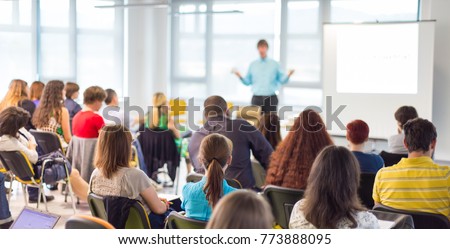 Business and entrepreneurship symposium. Speaker giving a talk at business meeting. Audience in conference hall. Rear view of unrecognized participant in audience. Royalty-Free Stock Photo #773888095