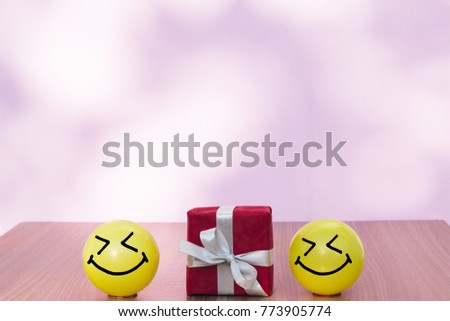 Smiley face yellow ball with Christmas present box

