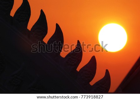 Roof of Thai Temple while sunset orange silhouette background