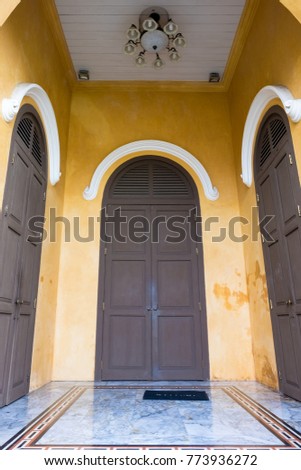 beautiful architectural molding on the narrow windows. Wooden door Vintage color cyan on peach colored wall for house and building architecture.Classic door decoration.