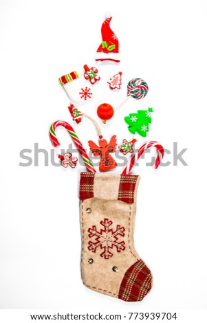 Christmas background with a sock from which scattered gifts, candy, New Year decorations toys on a white background. The concept of advertising, shopping, discounts and gifts for the winter holidays