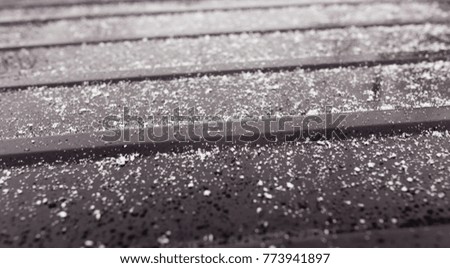 Snowflakes on a black car as a background