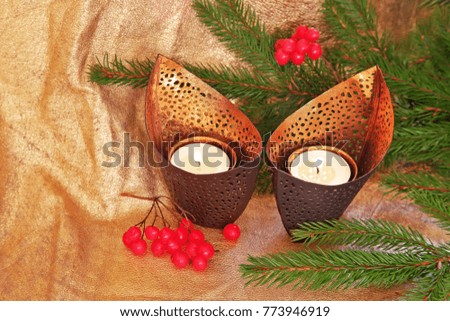 Candlelight with christmas tree branches on golden background 
