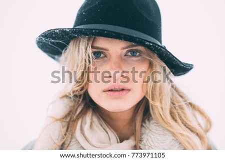 Winter day. Beautiful winter portrait of young woman in the winter snowy scenery.