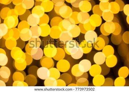 Blurred photo of yellow bokeh background of defocused glittering lights