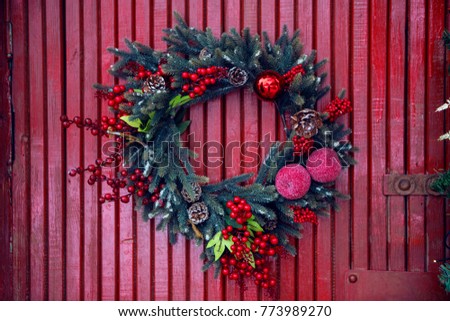 pine garland for Christmas hanging on red wooden wall