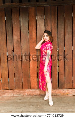 Asian woman in Chinese traditional dress posing in the old town market. Chinese new year concept