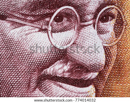 Mahatma Gandhi face portrait on India 200 rupee (2017) banknote close up macro, leader of the Indian independence movement, father of nation Royalty-Free Stock Photo #774014032