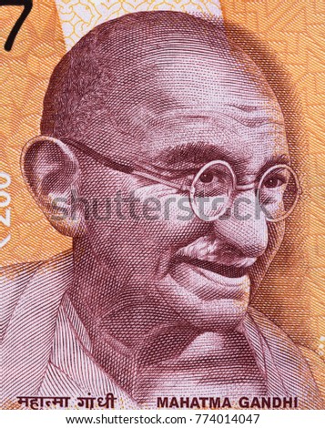 Mahatma Gandhi face portrait on India 200 rupee (2017) banknote close up macro, leader of the Indian independence movement, father of nation Royalty-Free Stock Photo #774014047