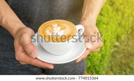 Men holding a cup of hot latte coffee.