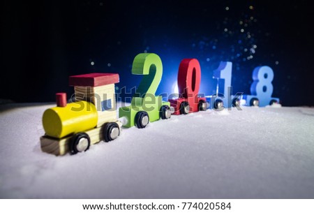 2018 happy new year,wooden toy train carrying numbers of 2018 year on snow. Toy train with 2018. Copy space. Christmas decoration. Selective focus. Dark background